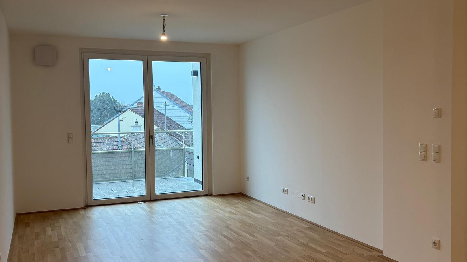 Ansicht eines geräumigen Wohnraumes mit hellem Parkettboden