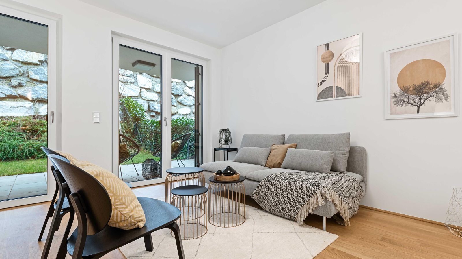 Darstellung Wohnzimmer mit hellem Parkettboden,  Mustermöblierung und Gartenzugang
