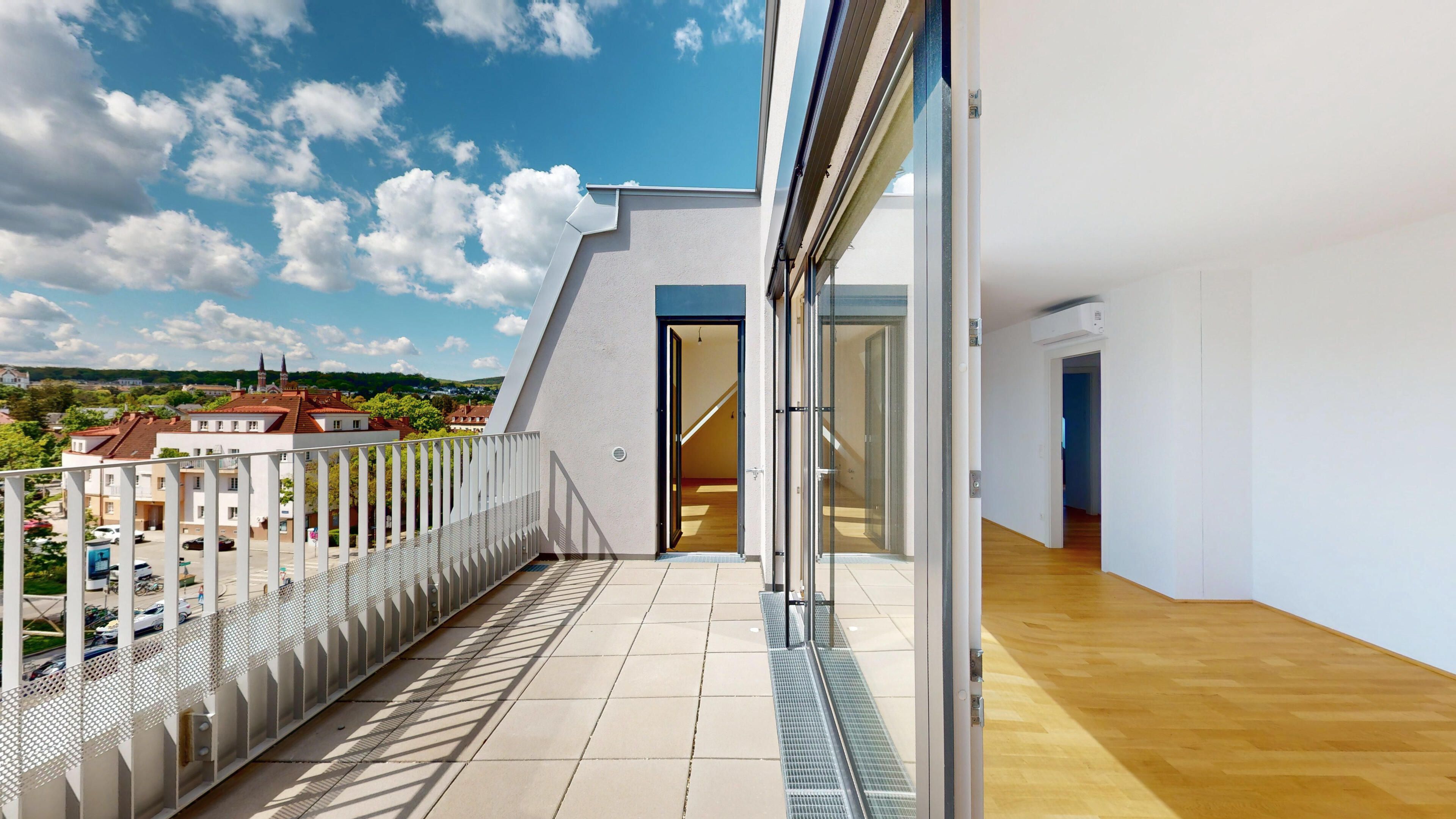 Ansicht der Terrasse mit Blick in die Weite sowie Blick in den Wohnraum
