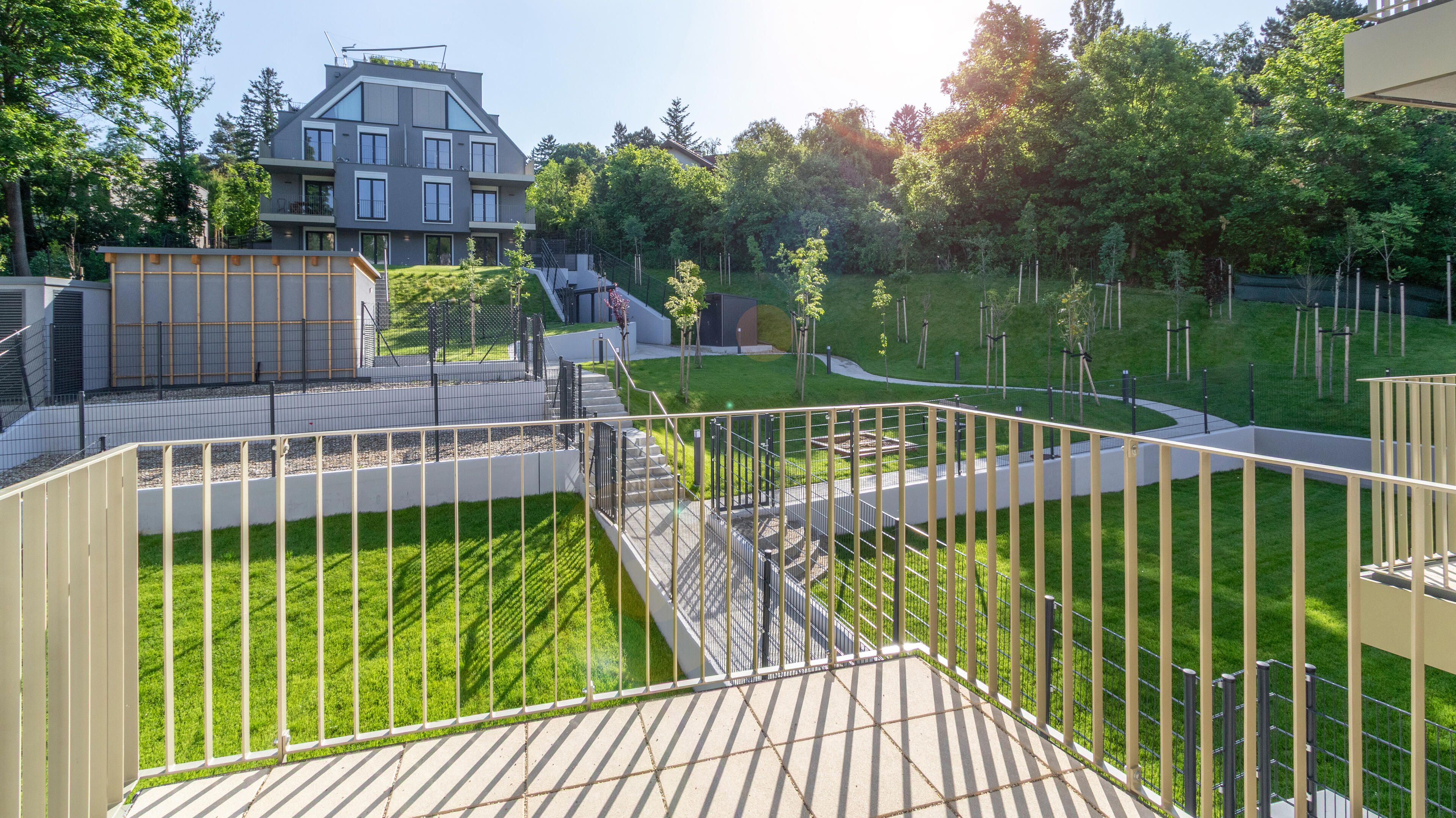 Ansicht von der Terrasse in den großzügigen, begrünten Innenhof mit Blick auf den gegenüberliegenden Baukörper
