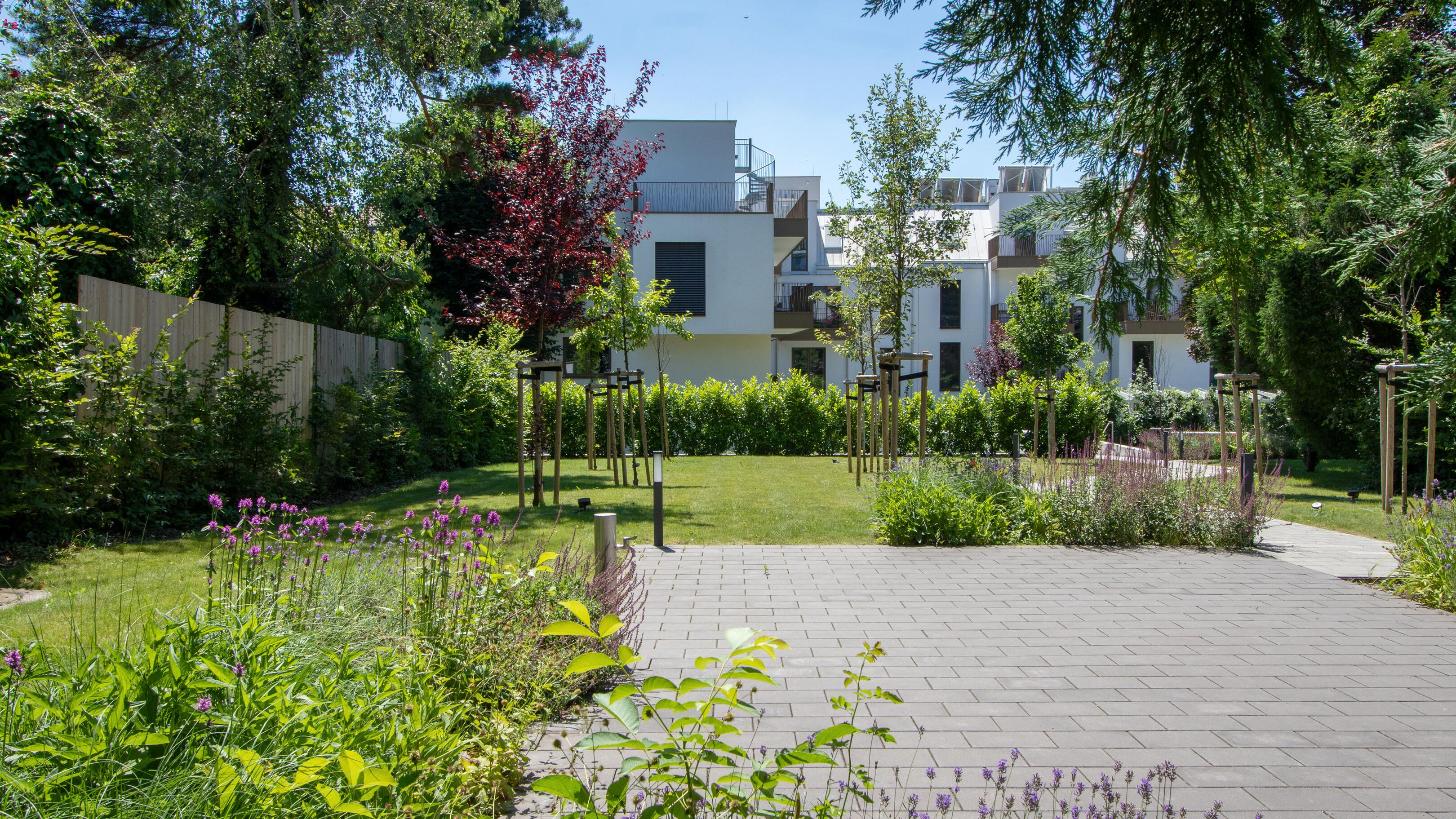Innenhof mit viel Grün und gepflasterter Terrassenfläche