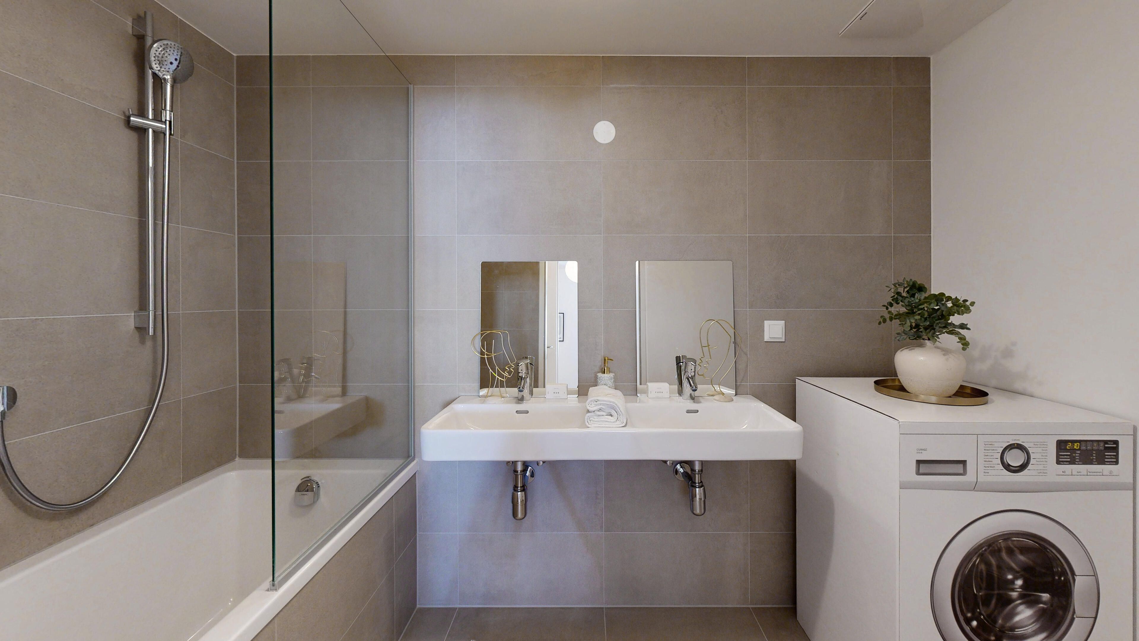 Ansicht des Badezimmers mit Doppelhandwaschbecken und Badewanne