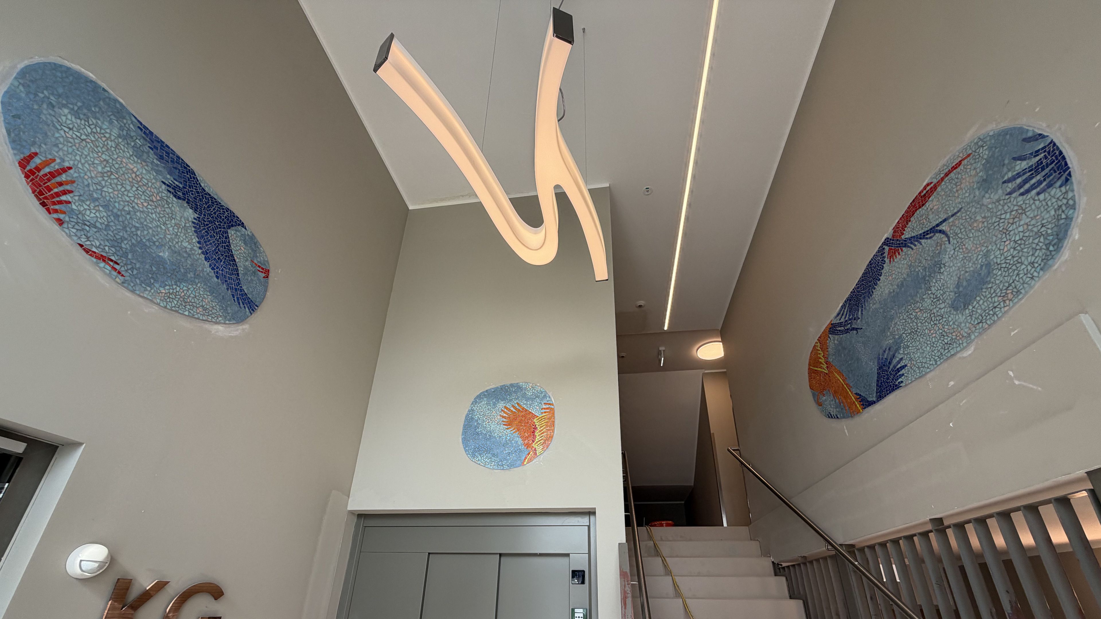 Bild zeigt das Kunstwerk: wolkenartige, in Mosaiktechnik ausgeführte Gebilde zeigen fragmentierte Schwingen des Fasans, bunt und lebendig.