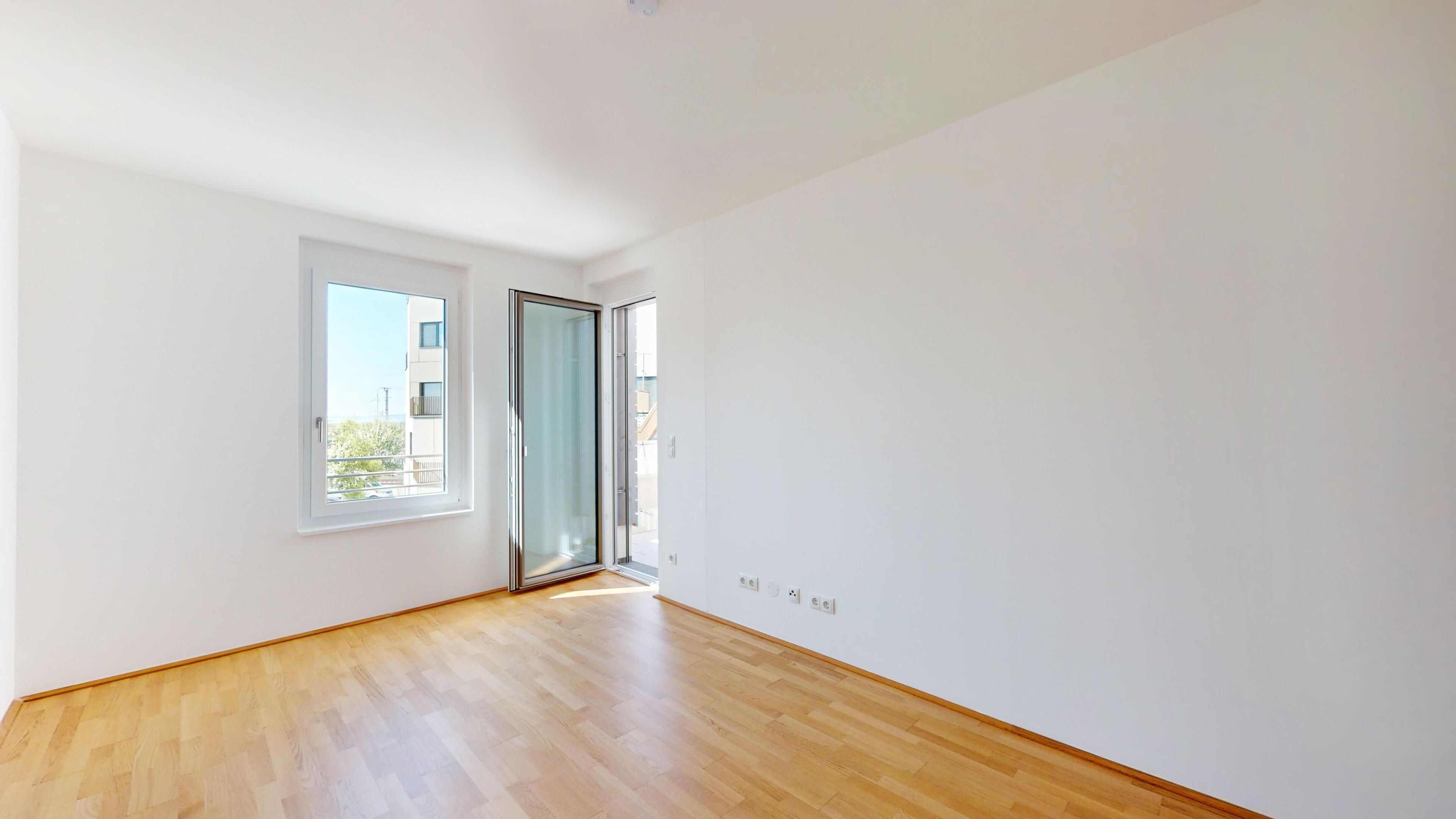 Darstellung Wohnzimmer mit hellem Parkettboden und Blick auf den Balkon