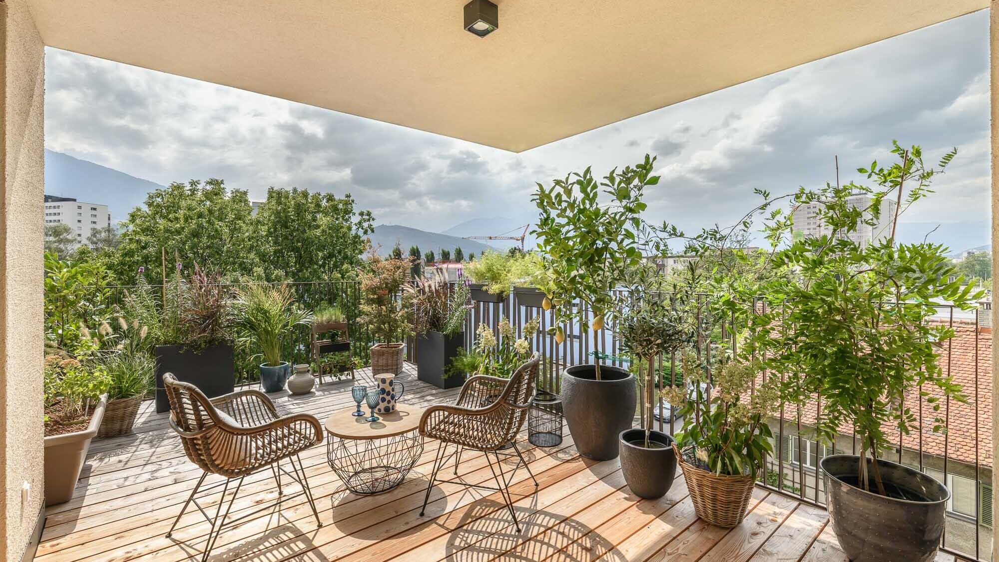 Darstellung der Terrasse mit Mustermöblierung und Blick auf die Berge