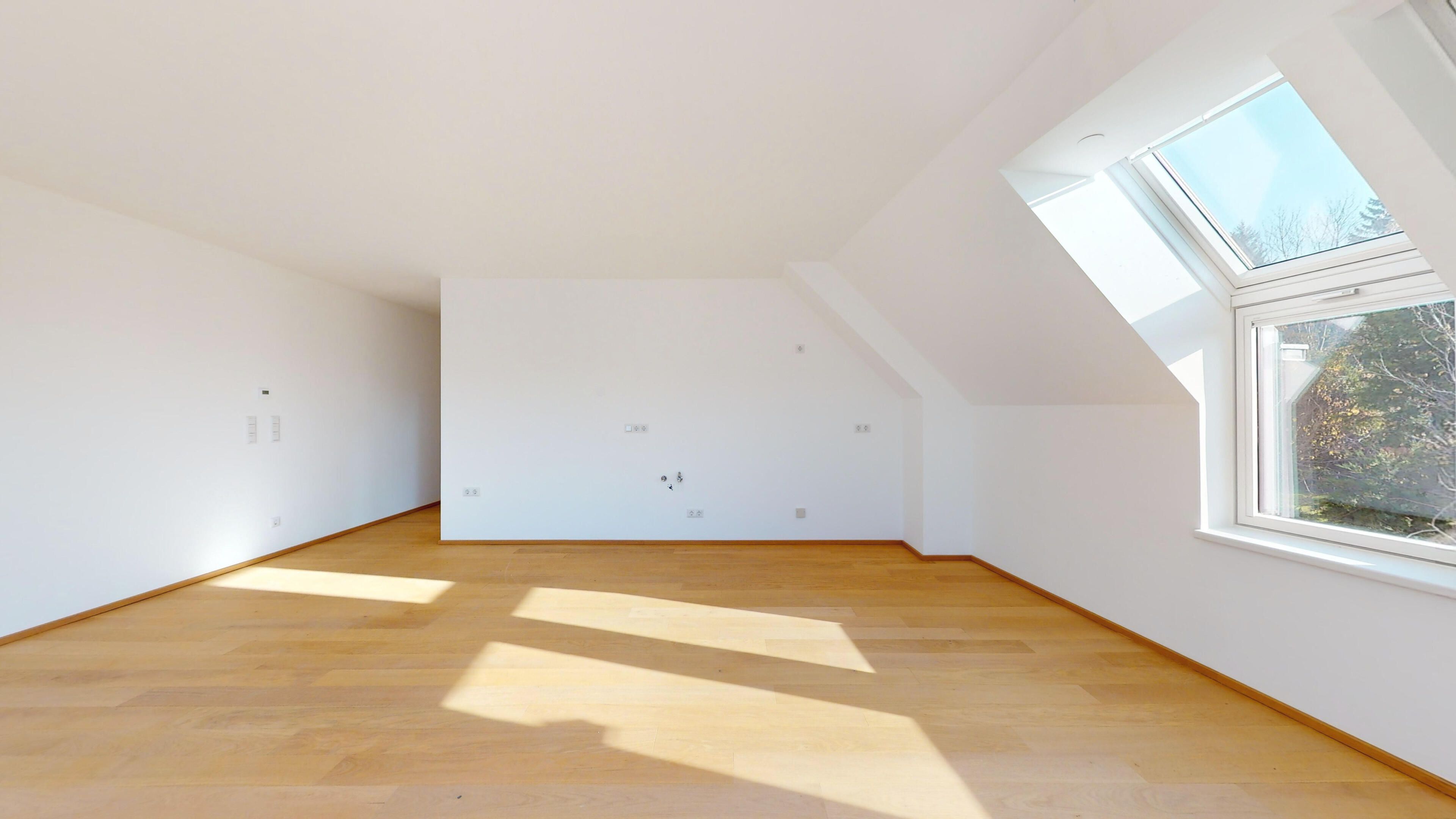 Ansicht eines geräumigen Wohnraumes und Küche mit Dachfenstern