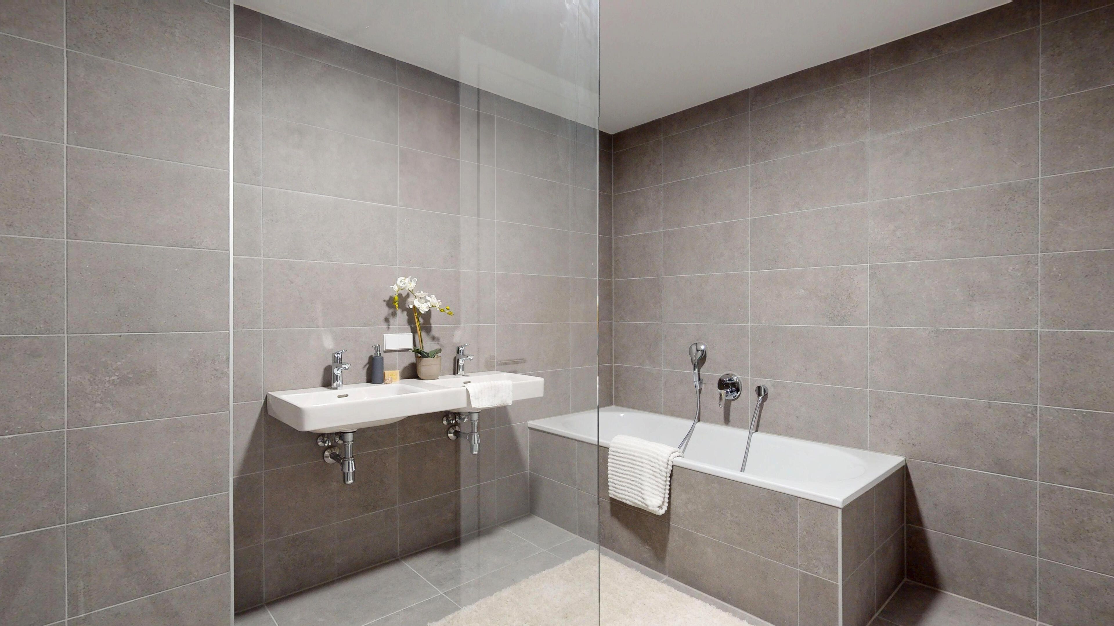 Ansicht eines Badezimmers mit Doppelwaschbecken und Badewanne