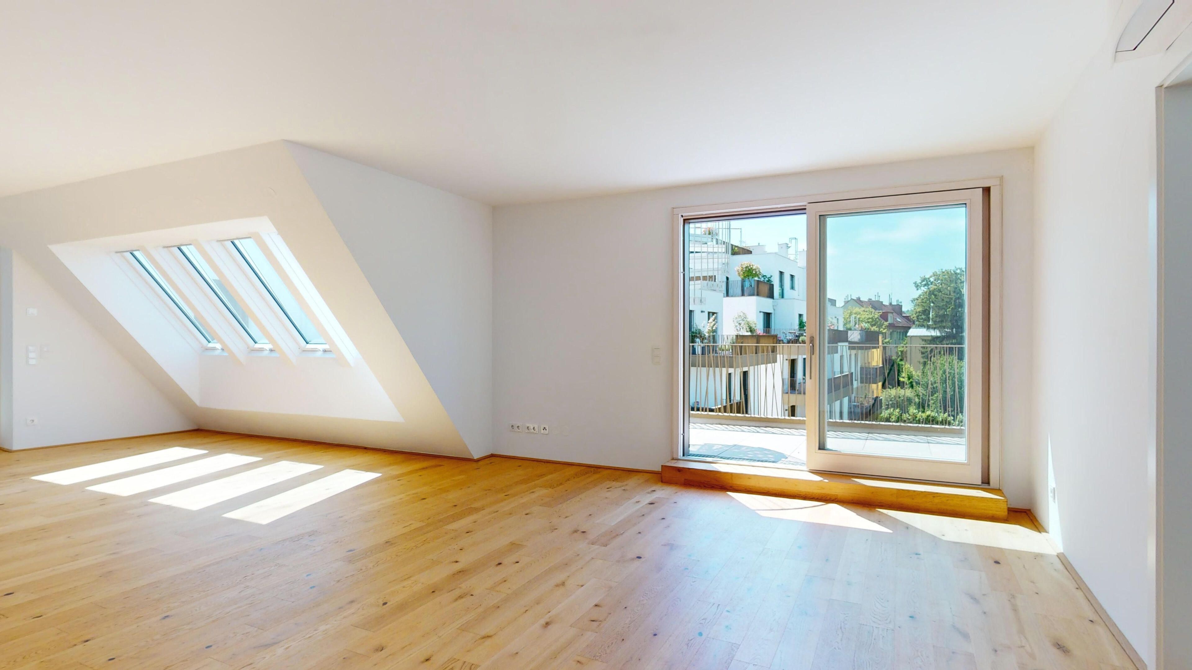 Ansicht eines sehr hellen Wohnraums mit Zugang zur Terrasse