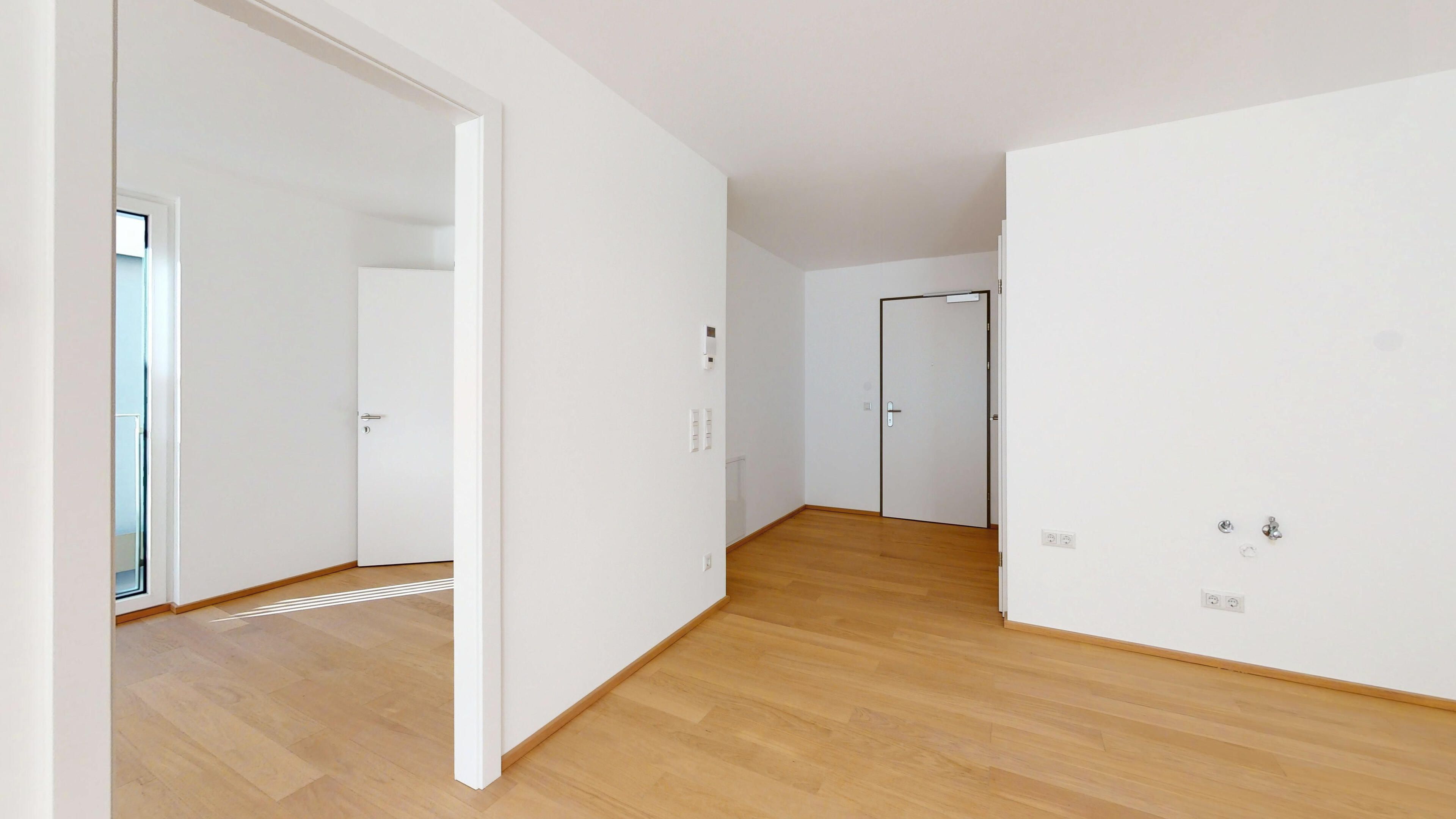 Ansicht eines geräumigen Wohnraumes mit Küche mit Blick Richtung Eingang