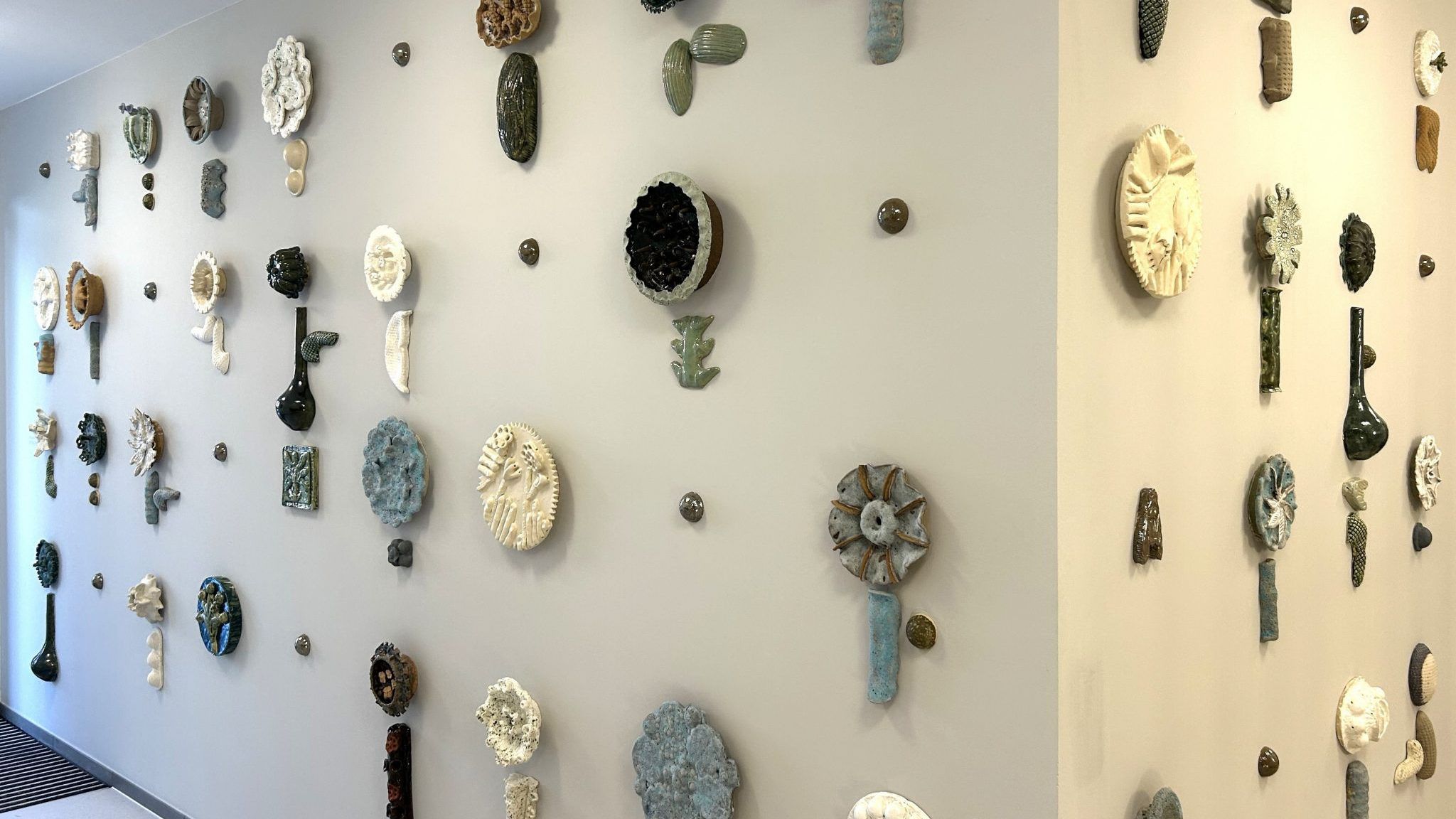 Das Kunstwerk ist eine Installation keramischer, floraler Elemente in individuell gearbeiteten blütenähnlichen Formen. 