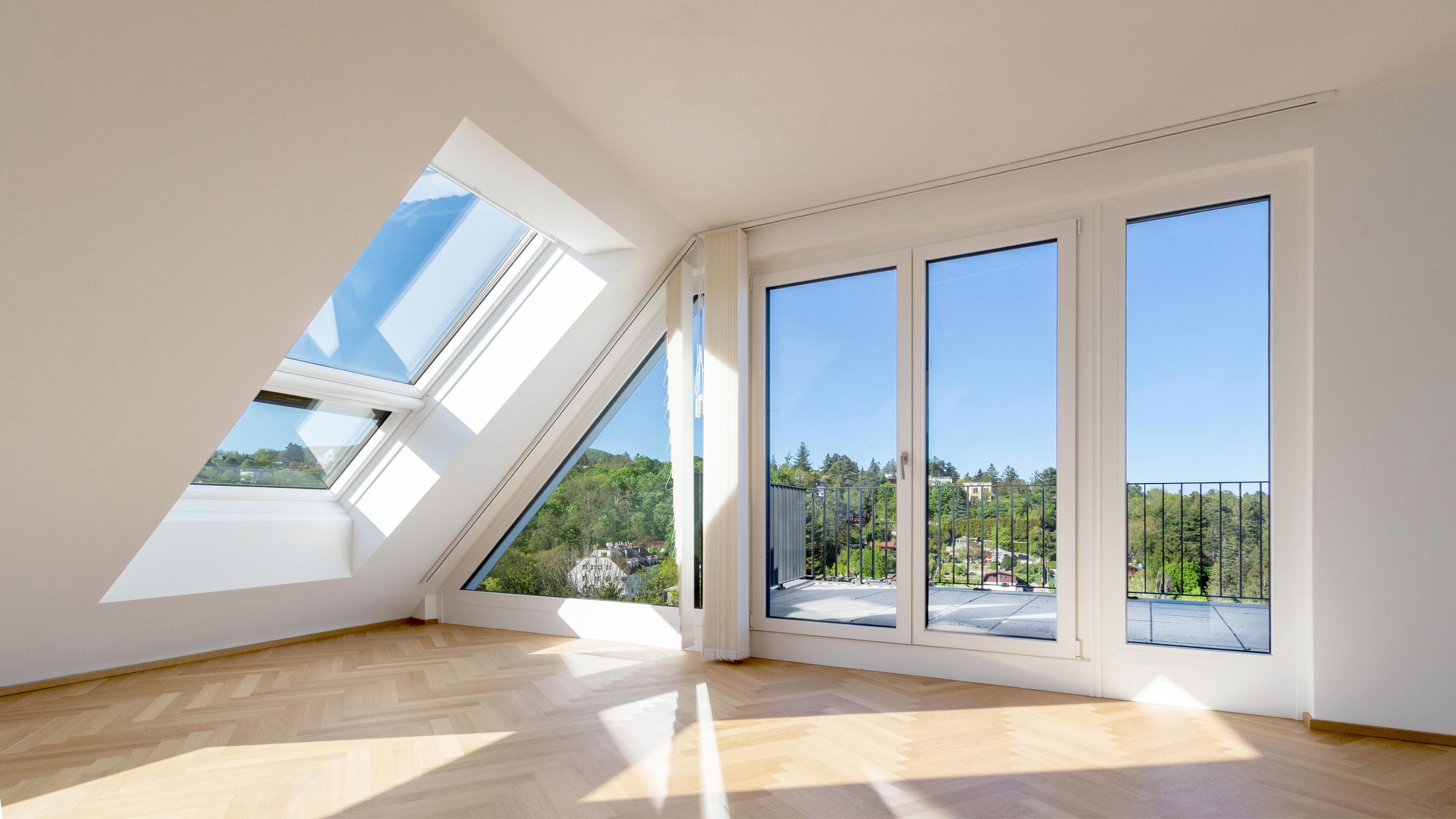 Sehr heller Wohnraum, frontal Fensterfront und seitlich Dachschräge.